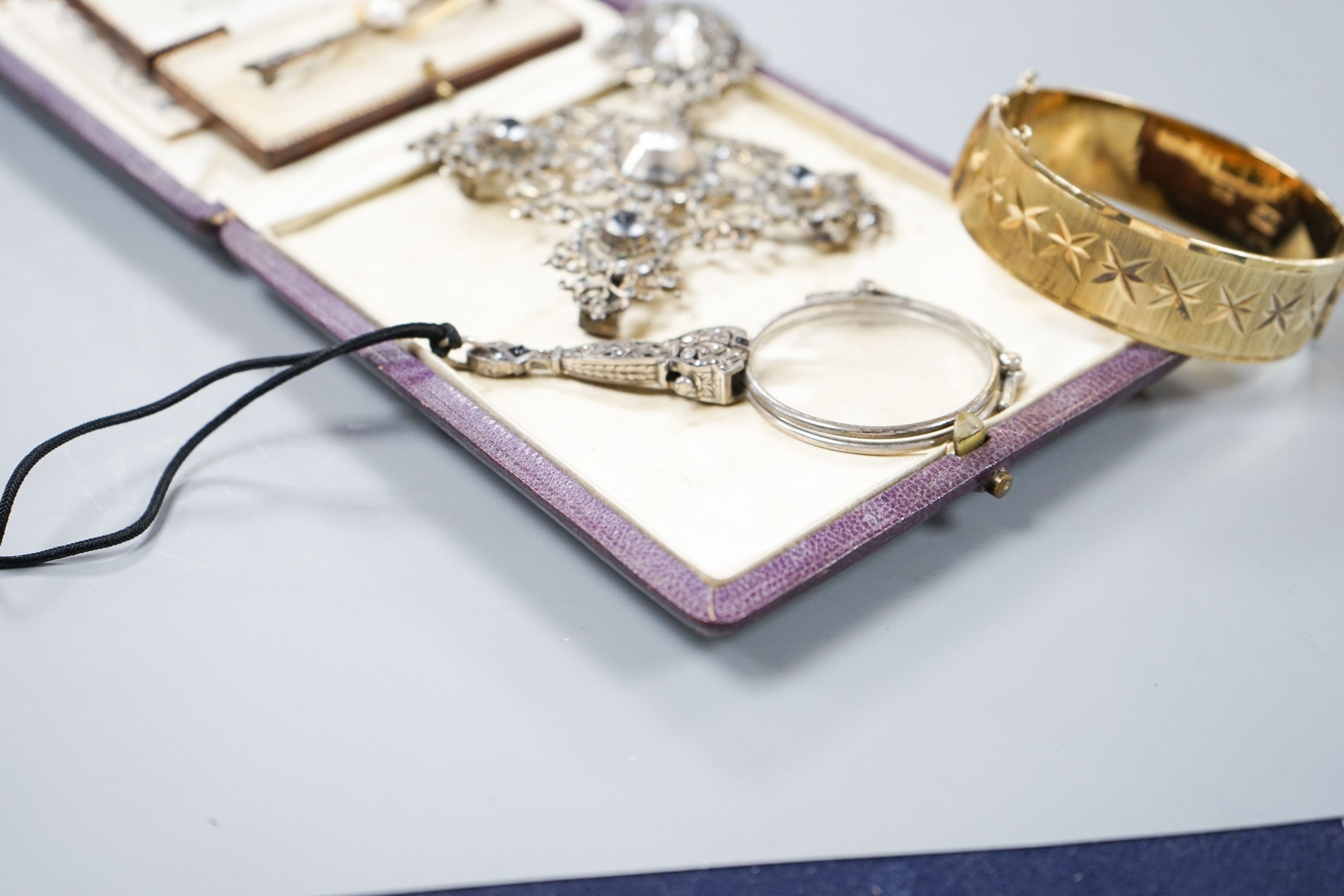 A white metal and paste set drop pendant, 10.7cm, a modern silver gilt bangle, a 9ct gold bar brooch, two other brooches and a marcasite set lorgnettes.